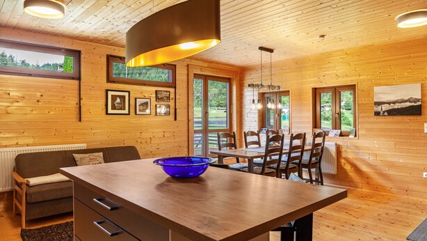 Un interior de madera con una isla de cocina, una mesa de comedor y sillas.