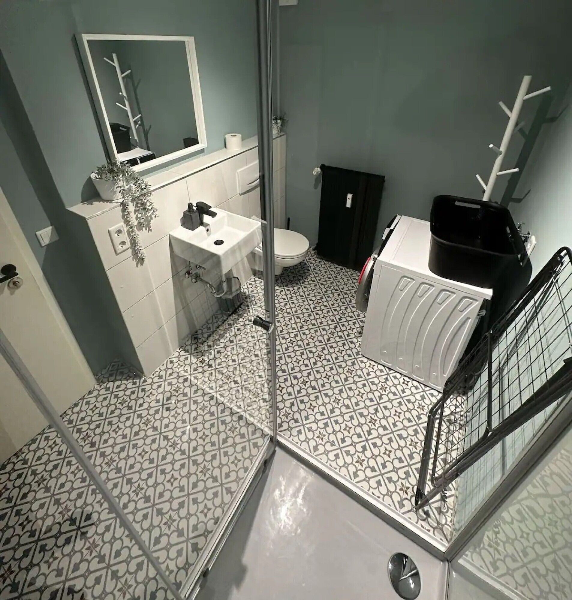 Un baño con lavamanos blanco, inodoro y zona de ducha.