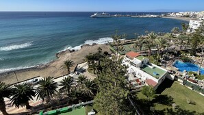A coastal hotel with a beach view, a swimming pool, and a large cruise ship in the background. - Ocean View 2 (Los Cristianos)