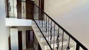 Una escalera con barandillas de hierro negro y peldaños blancos.