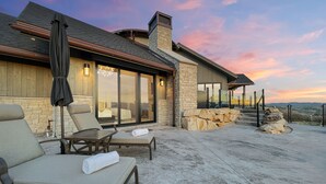 An outdoor patio with lounge chairs and a stone wall.