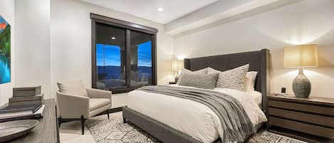 Un dormitorio moderno con una cama grande, un escritorio y una silla.