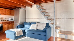 A modern kitchen with wooden cabinets, a microwave, and a refrigerator. - Ocean View Cottage, a Home in Madeira (Fajã da Ovelha)