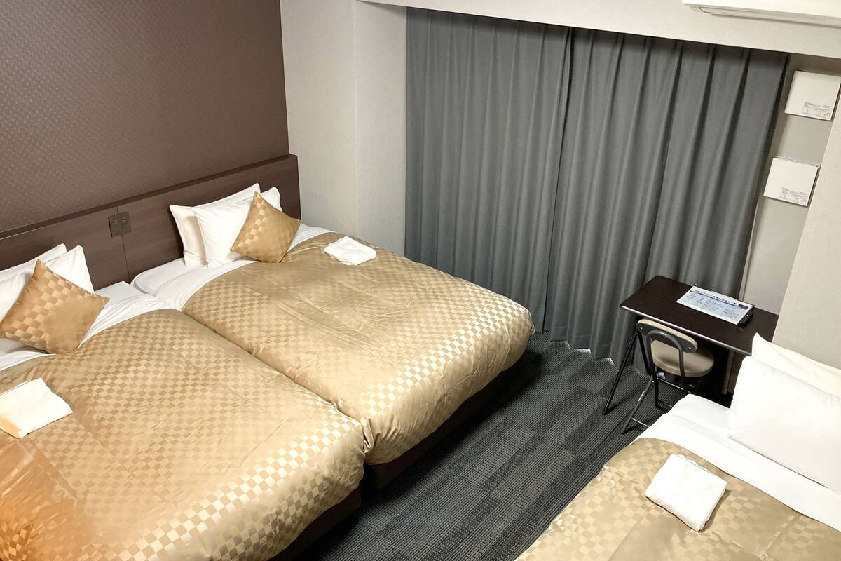 Une chambre d’hôtel avec un lit double, un bureau et une chaise.