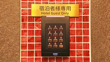 Ein elektronisches Keypad in einem Hotelzimmer, mit einem Schild mit der Aufschrift 'Nur für Hotelgäste' darüber.
