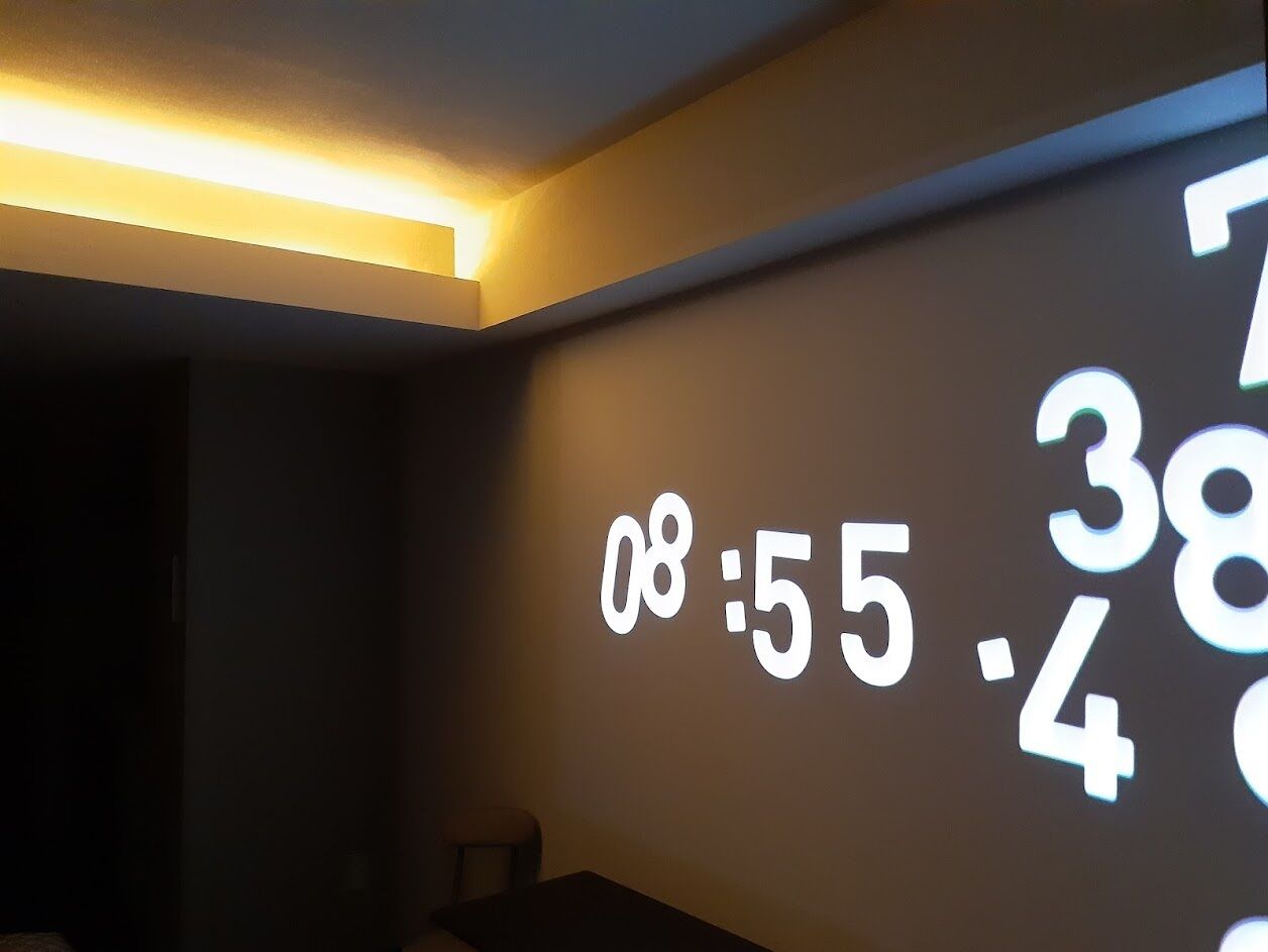 A wall with a digital clock displaying 08:55.