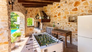 A stone-walled room with a foosball table, a wooden table, and a refrigerator. - Villa Damiana in Domijani i (Zminj)