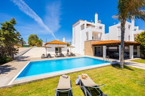 A modern hotel with a swimming pool, outdoor seating, and a well-maintained garden. - Villa Pelagos Blue in Rhodes (Rhodes)