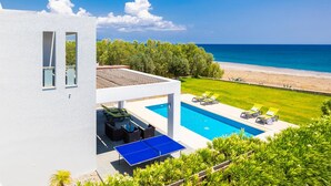 Et moderne hus med swimmingpool, udendørs siddeplads og havudsigt.