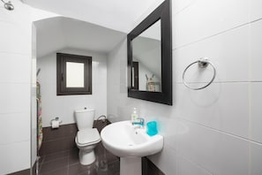 A modern bathroom with a toilet, sink, and a mirror.