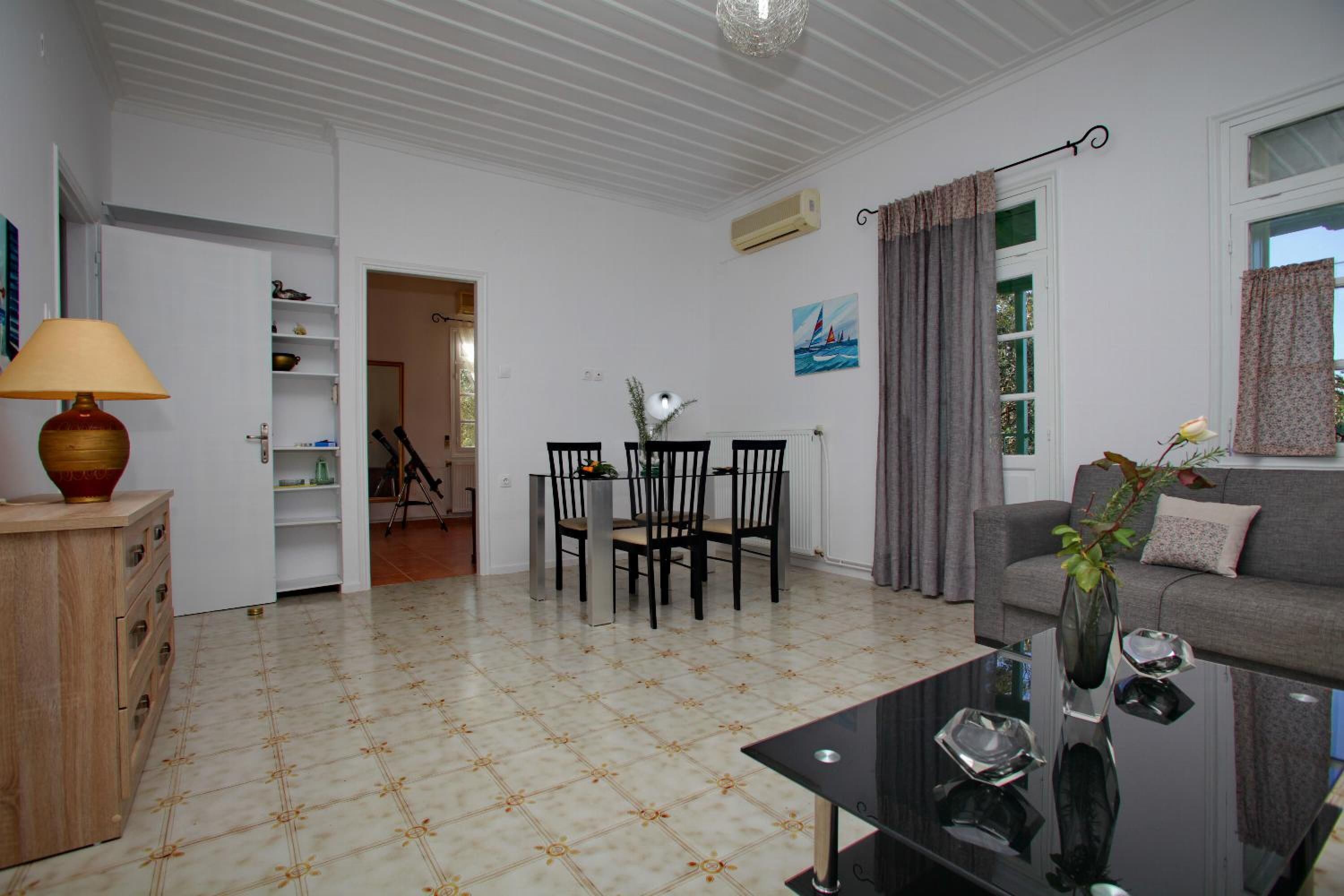 A living room with a dining table, chairs, a sofa, and a coffee table.