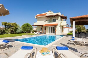 A modern two-story house with a swimming pool, lounge chairs, and a covered patio area. - Hermione Villa in Gennadi (Rhodes)