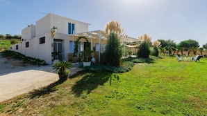 A modern house with a white exterior, a blue door, and a covered patio area. - Villa Padima in Scicli (Scicli)