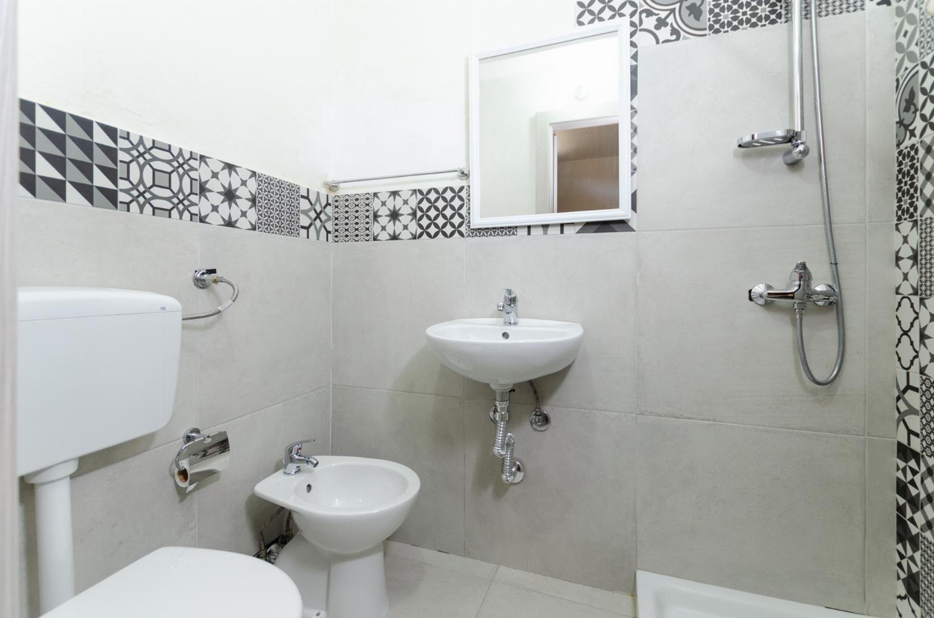 Un baño con inodoro, bidé, lavabo y ducha.