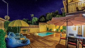 A wooden deck with a pool, outdoor seating, and a dining area. - Villa Dimi in Tsilivi (Zakynthos)
