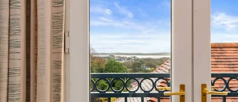Vista desde un balcón con baranda de metal y una puerta con picaporte amarillo.