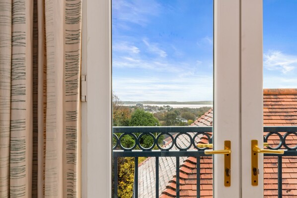A view from a balcony with a metal railing and a door with a yellow handle.