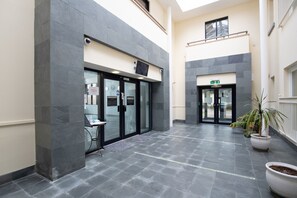 Un bâtiment moderne doté d’un espace d’accueil, de portes vitrées et d’un sol carrelé.