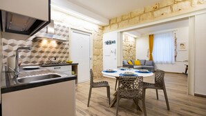 Une cuisine moderne équipée d’une cuisinière intégrée, d’un évier et d’un coin repas avec une table ronde et des chaises.