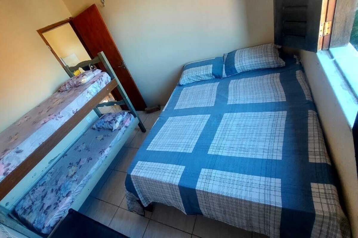 A small room with two bunk beds, a wooden door, and a window.