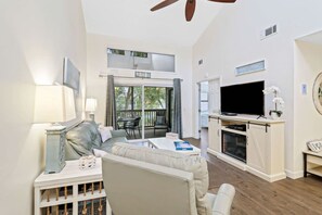 Ein Wohnzimmer mit einer Couch, einem Fernseher und einem Kamin.