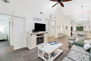 A spacious living room with a television, fireplace, and seating area.
