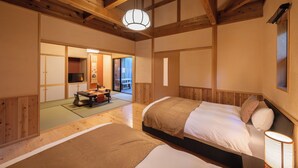 A traditional Japanese-style room with tatami flooring, wooden beams, and a bed with a headboard. - Tsuwabuki-no-Hana (Higashisonogi)