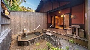 A wooden deck with a hot tub, stone flooring, and a small wooden table. - Tsuwabuki-no-Hana (Higashisonogi)