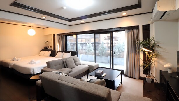 A hotel room with a bed, sofa, coffee table, TV, and a large window. - Sunmall Crest607 (Tokyo)