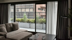 A modern living room with a sofa, a table, and a large window offering a view of the cityscape. - Sunmall Crest607 (Tokyo)