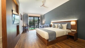 Un dormitorio moderno con una cama grande, ventilador de techo y vistas al exterior.