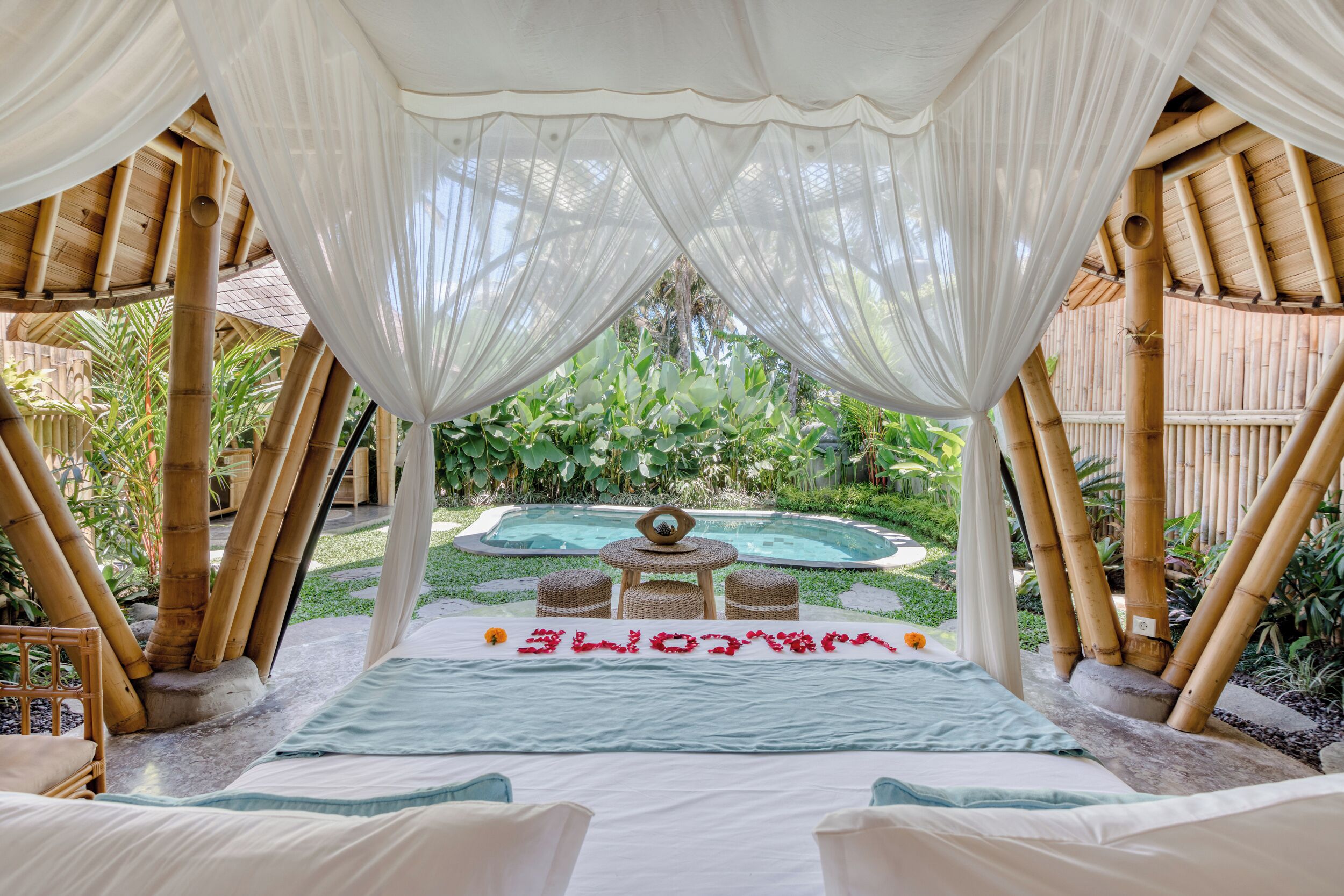 A private outdoor seating area with a canopy, a pool, and a garden.
