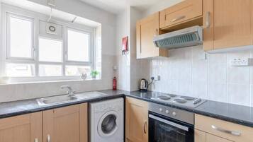 A modern kitchen with a built-in washer, oven, and stove.