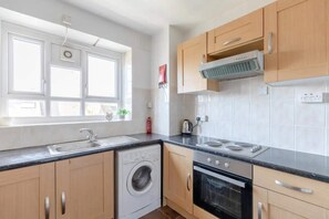 A modern kitchen with a built-in washer, oven, and stove.