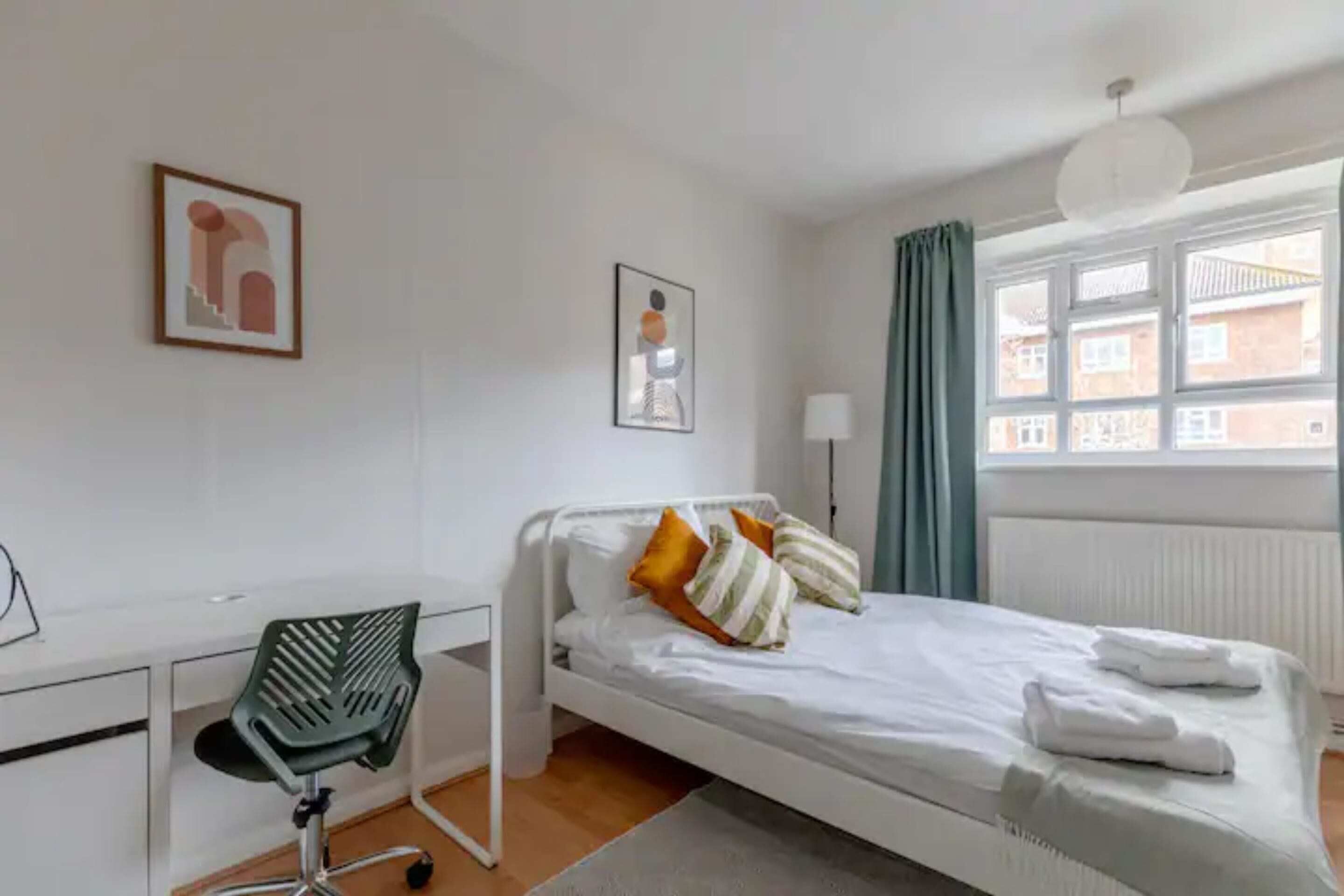 A hotel room with a bed, a desk, and a chair.