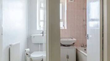 A bathroom with a toilet, a sink, and a shower.