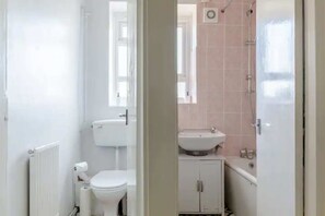 A bathroom with a toilet, a sink, and a shower.