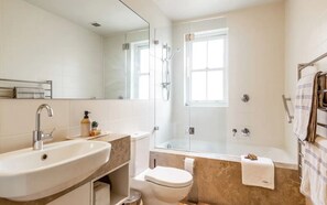 A modern bathroom with a sink, toilet, and glass-enclosed shower. - Balmain Wharf Apartments - #1 (Inner West Council)