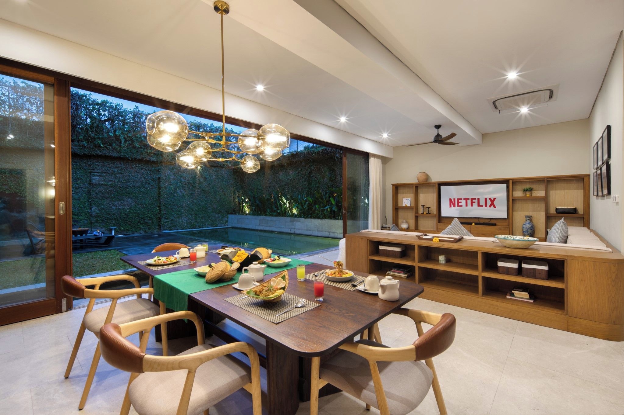 A modern dining area with a wooden table, chairs, and a buffet setup.
