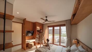 Ein modernes Hotelzimmer mit Bett, Fernseher, Deckenventilator und Balkon mit Gartenmöbeln.