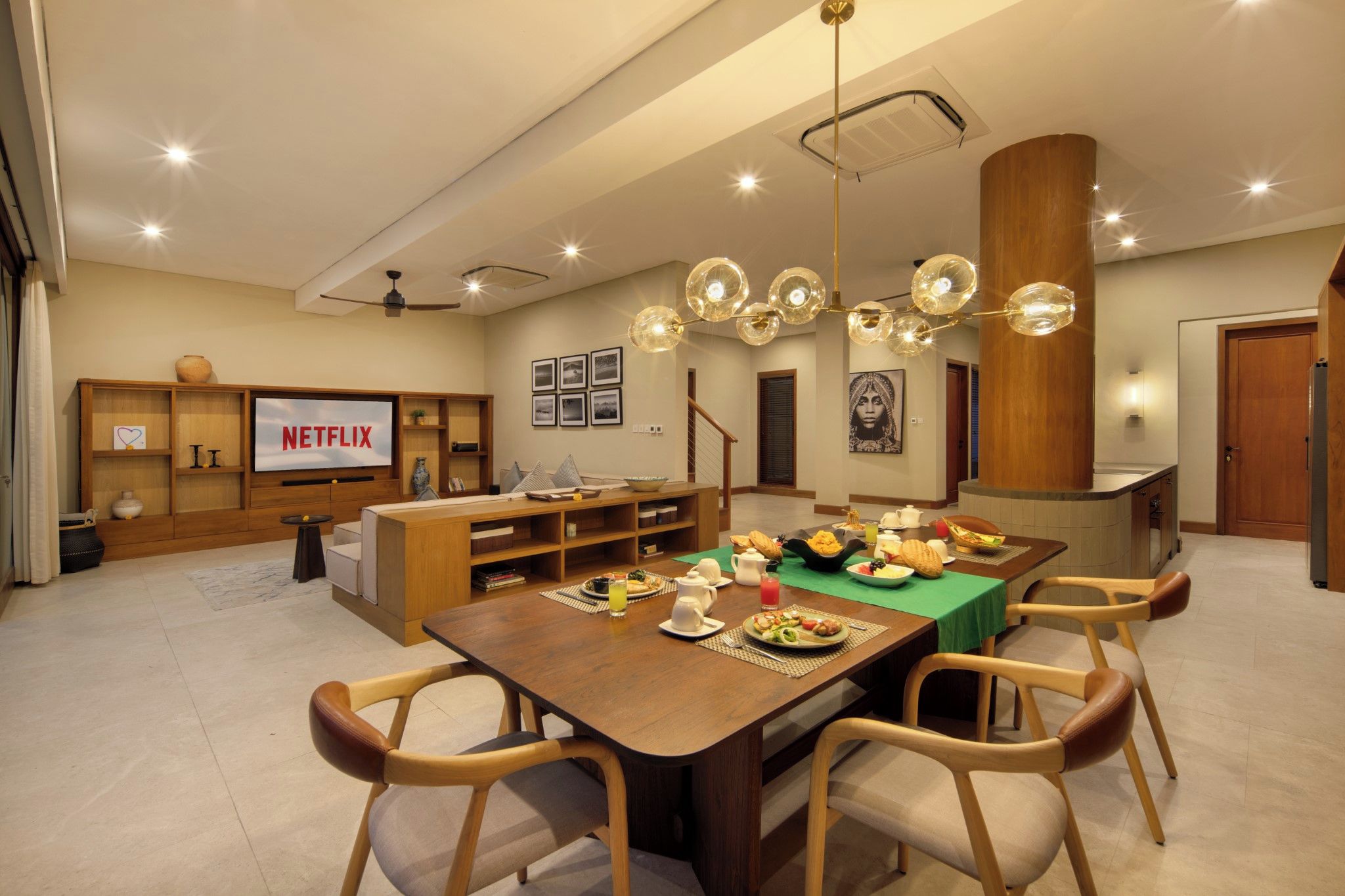 Un comedor moderno con una mesa de madera, sillas y una variedad de platos.