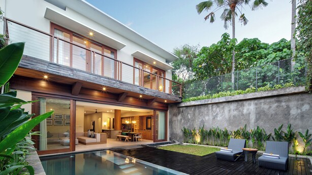 A modern house with a swimming pool, a balcony, and a garden with plants. - Kolila Villa Seminyak by Ini Vie Hospitality (Kerobokan)
