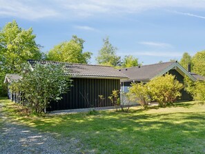 A single-story building with a dark exterior, a tiled roof, and a small porch area.