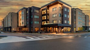 A modern hotel with a prominent entrance, multiple floors, and a well-lit facade. - Residence Inn by Marriott Arvada Denver West (Arvada)