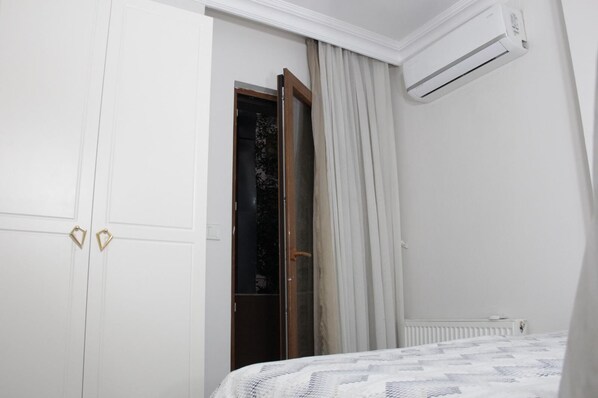 A bedroom with a bed, a wardrobe, a radiator, and an air conditioning unit. - Solo Suites Hotel (Istanbul)
