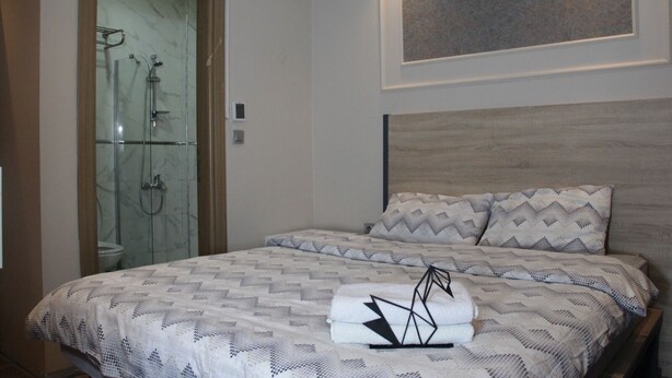 A bedroom with a bed, a headboard, a shower, and a wall-mounted air conditioner. - Solo Suites Hotel (Istanbul)