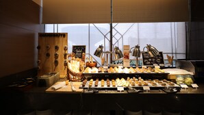 A bakery display with various baked goods and a chalkboard menu. - Fortune Park, East Delhi - Member ITC Hotels' Group (New Delhi)