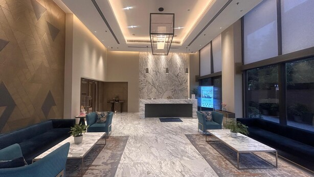 A modern lobby with a marble floor, two sofas, a reception desk, and a digital information kiosk. - Fortune Park, East Delhi - Member ITC Hotels' Group (New Delhi)