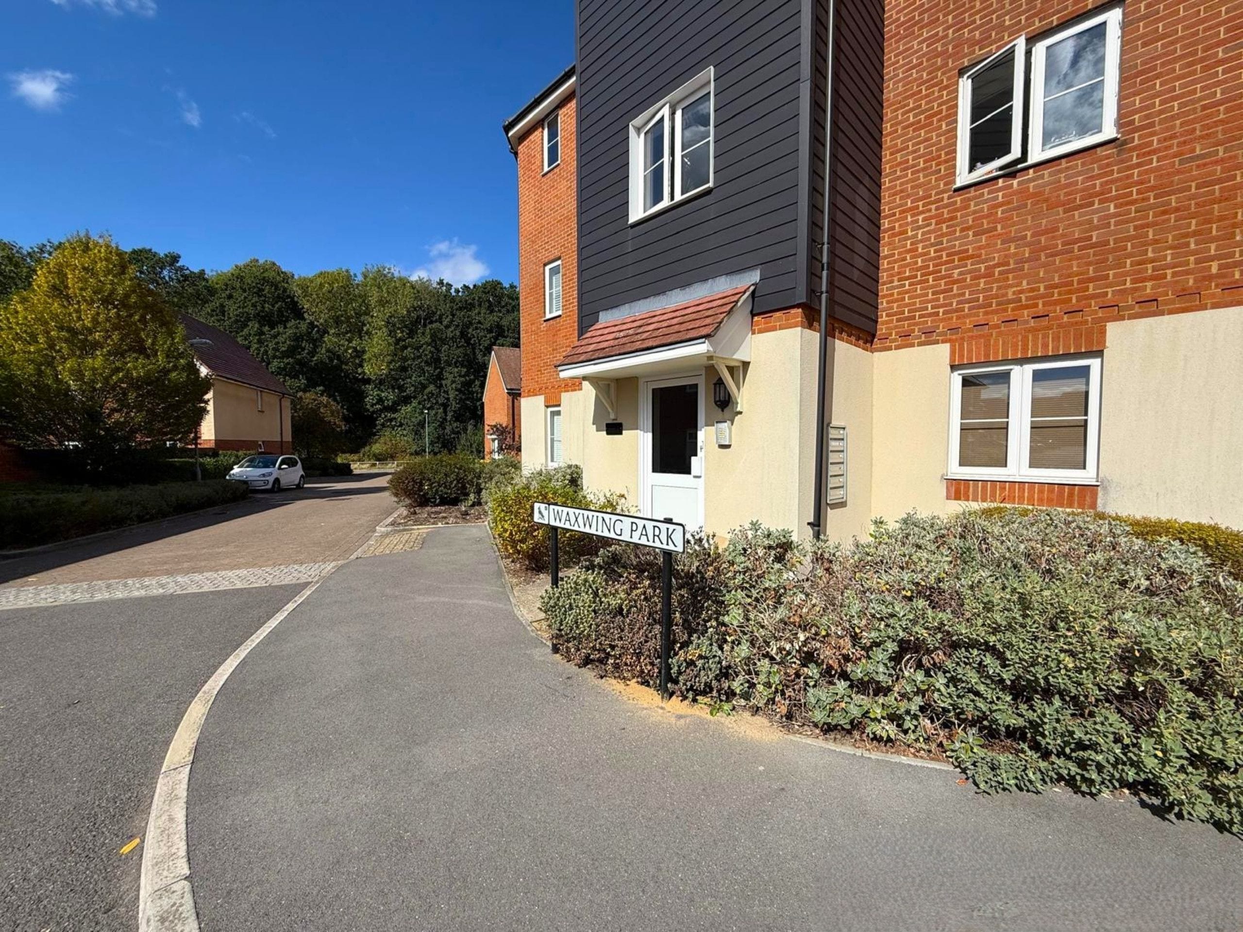 A residential street with a house labeled 'WAXWING PARK' and a paved driveway.