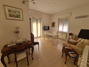 Un salon avec une table à manger en bois, un canapé et un téléviseur.